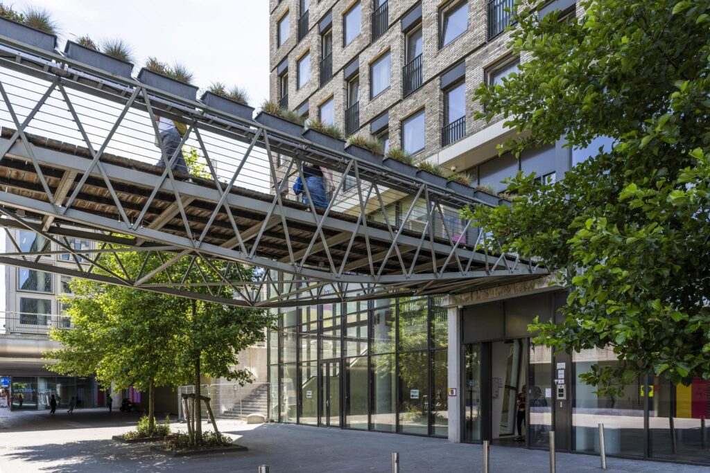 Modern pedestrian bridge with planters connecting buildings at Elizabeth Cady Stantonplein.